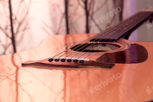 Preview: Acoustic guitar on a beautiful colored background. The concept of stringed instruments.