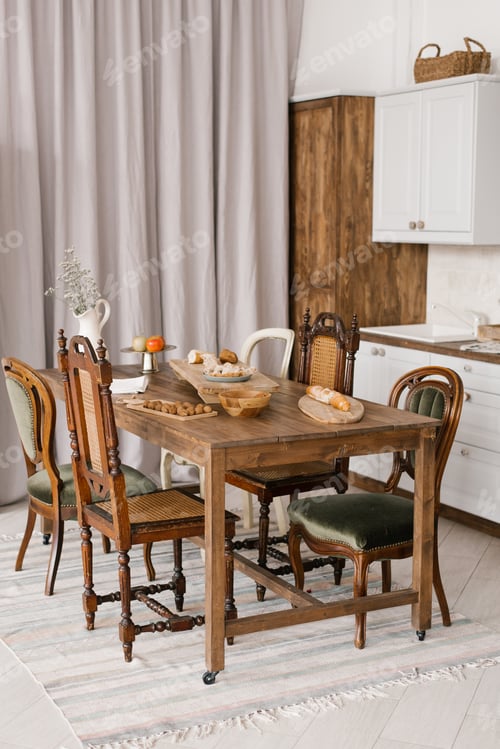 Preview: Kitchen Table with Food and Kitchenware with a Variety of Wooden Chairs in the Scandinavian Style