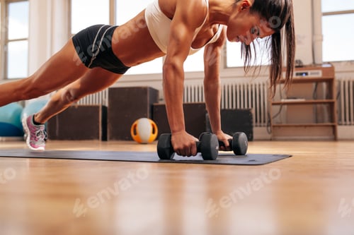 Preview: Fitness woman doing push ups exercise with dumbbells