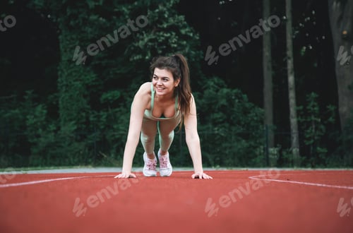 Preview: A young woman at the starting line in the stadium.