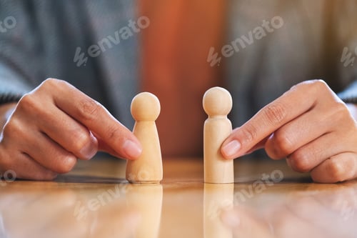 Preview: Businessman choosing two wooden people in the office