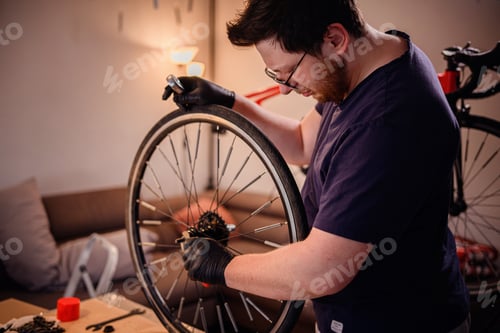Preview: Man Adjusting Bicycle Wheel Hub in Cozy Home Setting