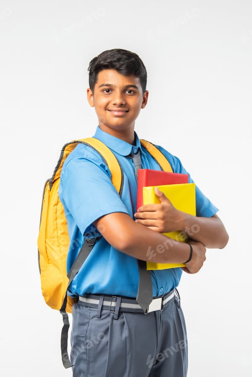 Preview: Indian Asian school boy in uniform with books or laptop and backpack, smiling and isolated