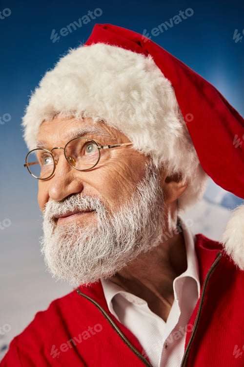 Preview: white bearded old man in Santa festive costume wearing glasses and looking away, winter concept