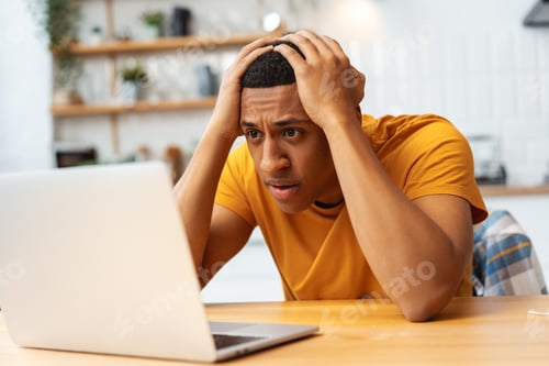 Preview: Unhappy Latin man, young student, sitting at workplace, using laptop, having problems, bad news