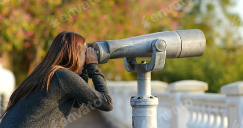 Preview: Woman tourist looking though the binocular at outdoor