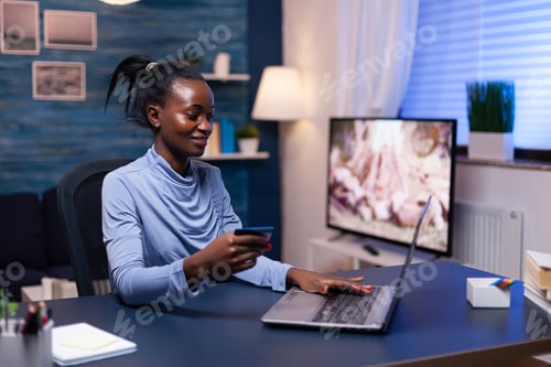 Preview: Dark skinned business woman holding credit card