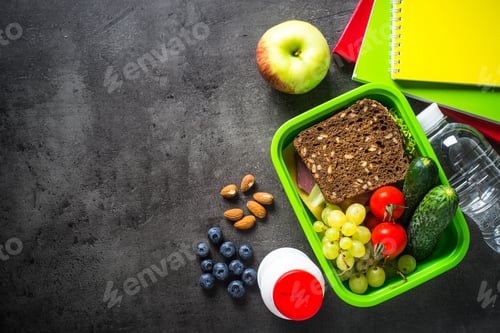 Preview: School lunch box and stationery on black background