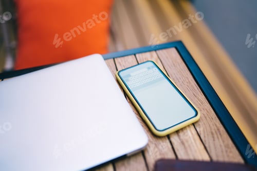 Preview: Smartphone and laptop placed on wooden table
