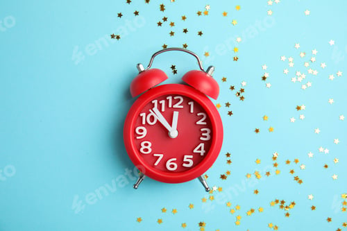 Preview: Flat lay composition with alarm clock and confetti on color background. Christmas countdown