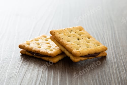 Preview: Biscuit with chocolate filling on wooden table