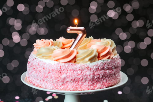 Preview: Celebration with a pink cake featuring a candle for a seventh birthday party