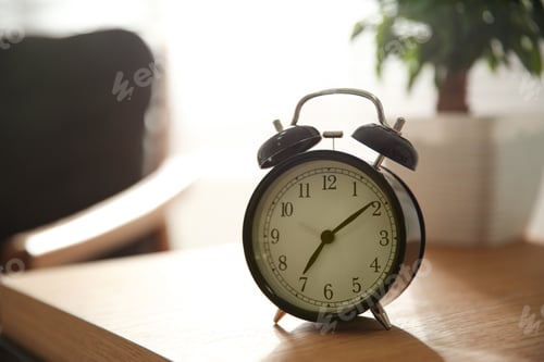 Preview: Alarm clock on wooden table at home. Morning time