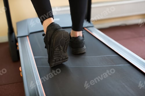 Preview: Man running in a gym on a treadmill.