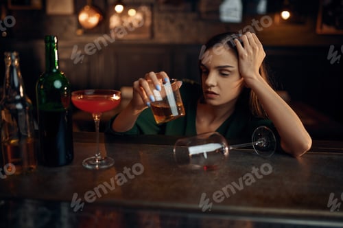 Preview: Drunk woman drinks alcohol at counter in bar