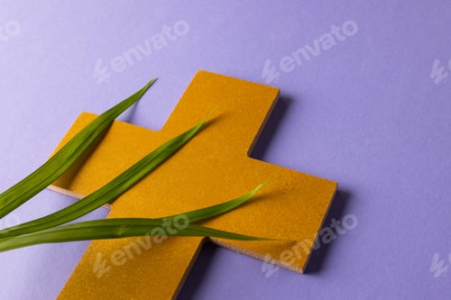 Preview: Composition of christian ash wednesday cross and palm leaves on purple background with copy space