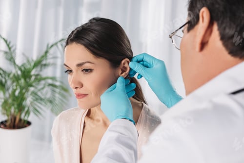 Preview: cropped image of doctor examining female patient ear