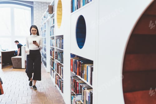 Preview: Asian woman reading smartphone in library