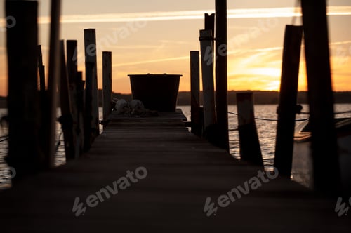 Preview: a dock with several fishing boats on it as the sun sets