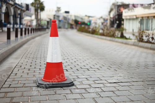 Preview: cone sign on the road. Striped orange cones on the asphalt road. Plastic orange cone on the road.