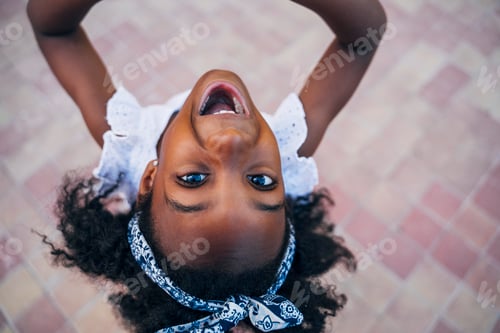 Preview: Cute mixed race girl having fun at street. Child innocence concept.