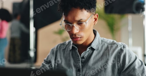 Preview: Man, photographer and glasses with laptop for production, film making or design at studio. Young, m