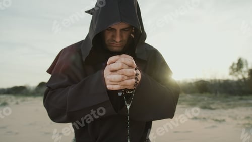 Preview: Religious Spiritual Monk Prays Alone In The Dune At Sunset