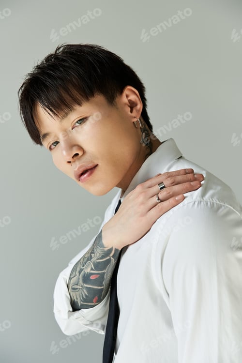 Preview: Stylish young man showcasing modern fashion in a minimalistic studio setting