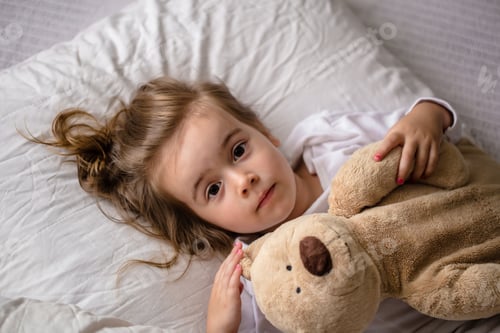 Preview: little girl in bed with soft toy the emotions of a child