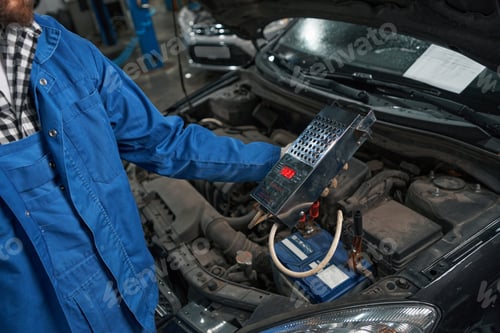 Preview: Man holding load plug for checking the battery
