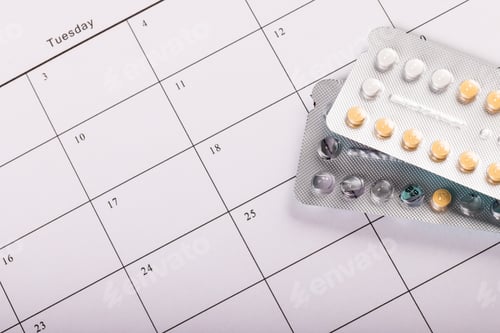 Preview: High angle close-up of blister packs of medicines on medication calendar, copy space
