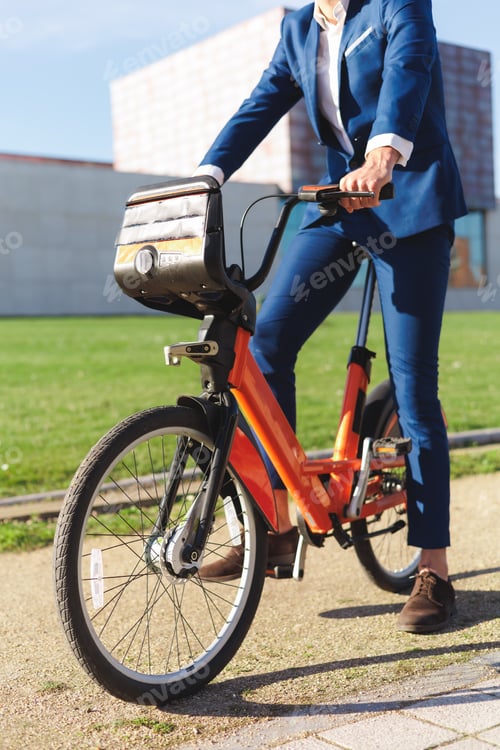 Preview: Unrecognizable businessman standing with an electric bike. Sustainable business concept.