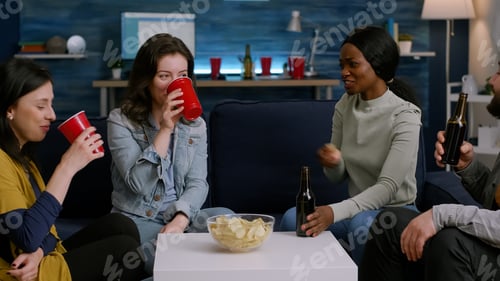 Preview: Mixed race friends cheering bottles of beer enjoying time spend together