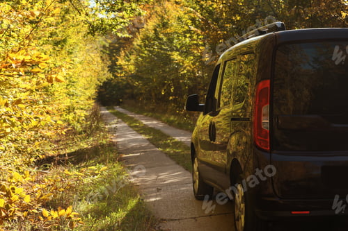 Preview: Car parked on country road near autumn forest. Space for text