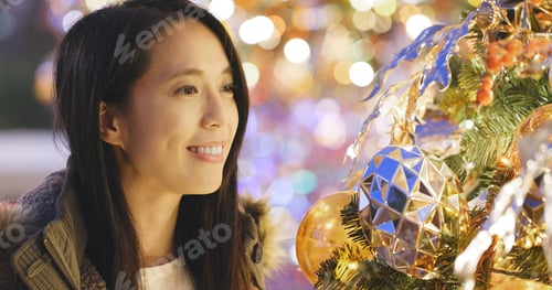 Preview: Woman looking at the christmas tree decoration