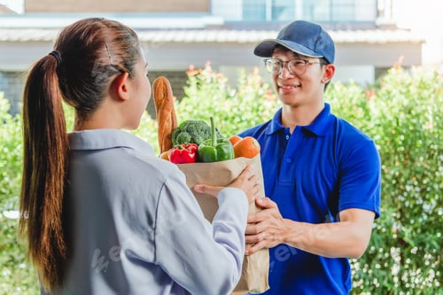 Preview: Food Delivery concept. Asian woman hand accepting bag of food, fruit