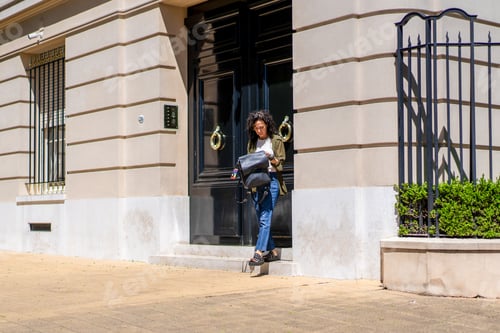 Preview: Casual woman stepping out into a sunny city scene