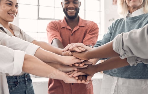 Preview: Group of diverse businesspeople piling their hands together in an office at work. Business professi