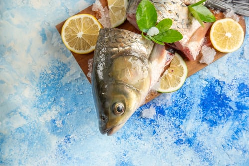 Preview: top view sliced fresh fish with lemon slices on light blue background dish food ocean seafood
