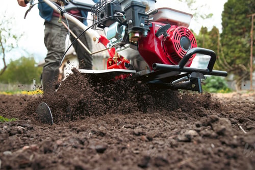 Preview: Farmer using tiller on a plowed field