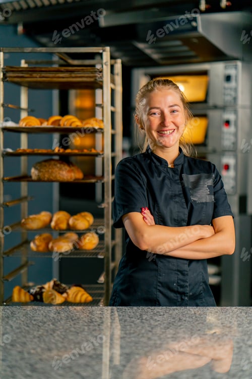 Preview: baker in a bakery against the background of ovens and a variety of fresh pastries
