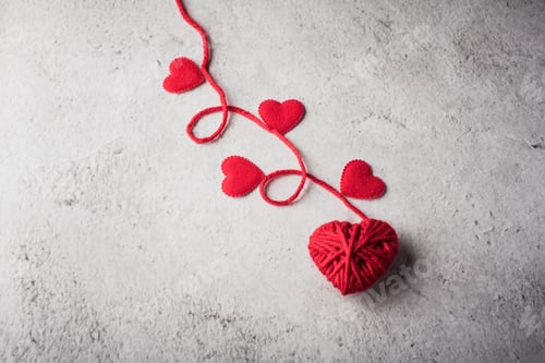 Preview: Red yarn heart shaped on the wall background