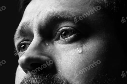 Preview: Sad man crying on dark background, closeup. Black and white effect