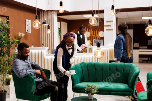 Preview: Waitress serving hotel guest in lobby