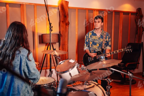 Preview: Guitar player and drummer jamming in a music studio.