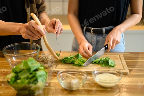 Preview: Young couple preparing a healthy homemade salad in the kitchen