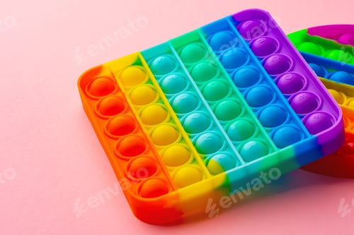 Preview: Colorful antistress pop it toy on pink background