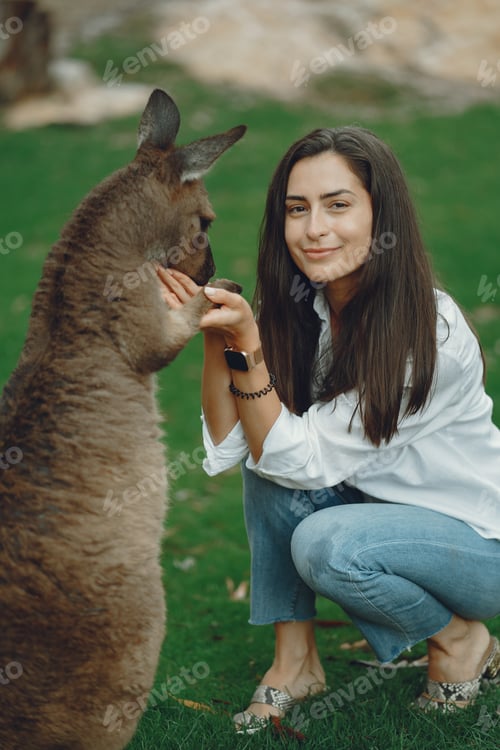 Preview: Woman in the reserve is playing with a kangaroo