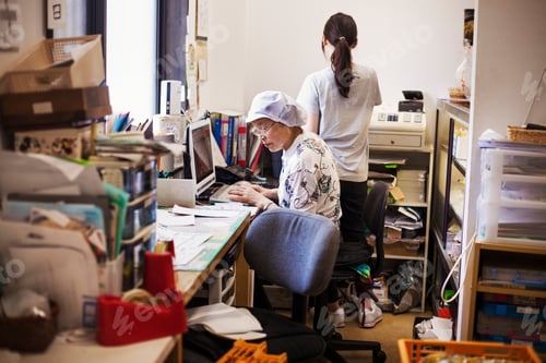 Preview: A mature woman at a desk in the office of a fast food unit and noodle production factory.