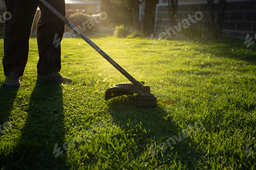 Preview: Garden worker with lawn mover. Garden works in spring.